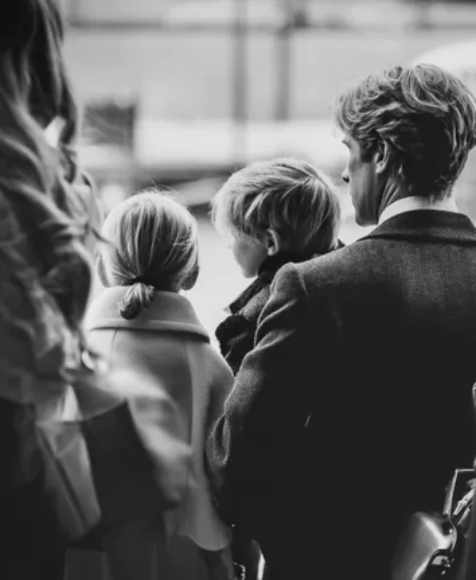 photograph of dad holding son at airport with daughter next to him